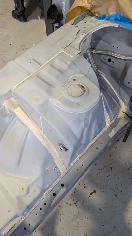 Ein nacktes Automobil-Chassis mit unvollständiger Lackierung und Schutzband.
